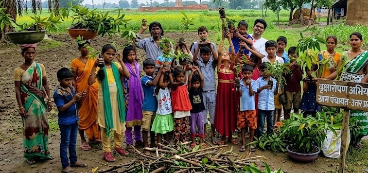 Volunteers and villagers planting tree saplings on barren land